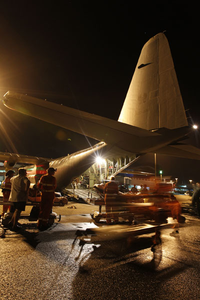 February 2011 –  Queensland Health members prepare patients for loading on board an Air Force C-130 Hercules at Cairns Airport. Operation YASI ASSIST.